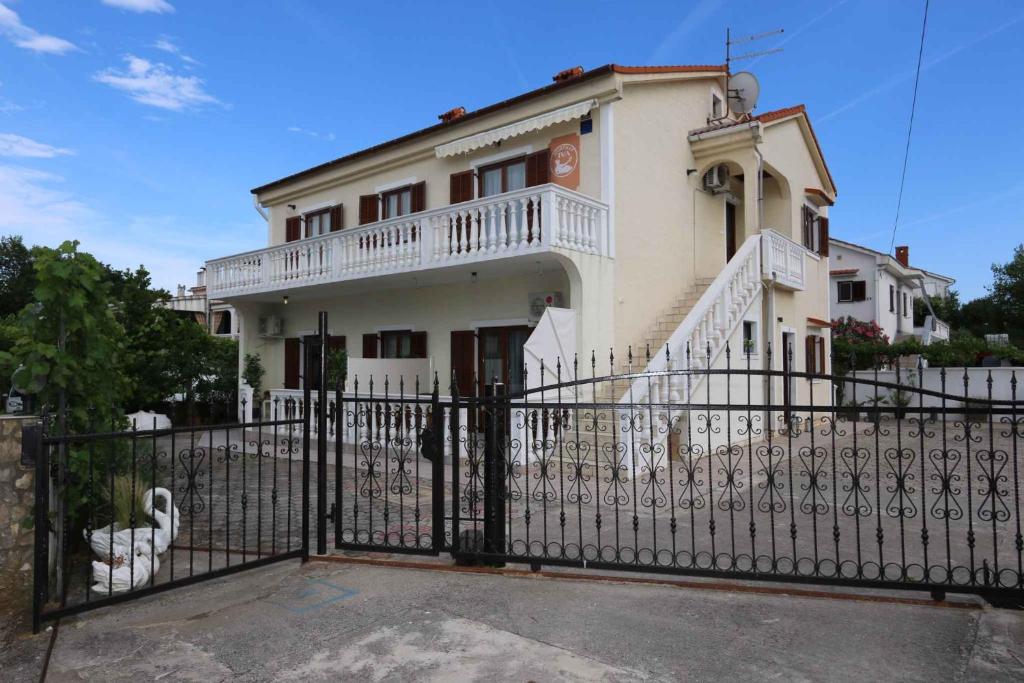 a white house with a fence in front of it at Apartment in Silo with Two-Bedrooms 10 in Šilo