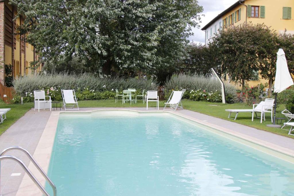 a large swimming pool with chairs and a table at Apartment in Lucca/Toskana 23961 in San Cassiano a Moriano