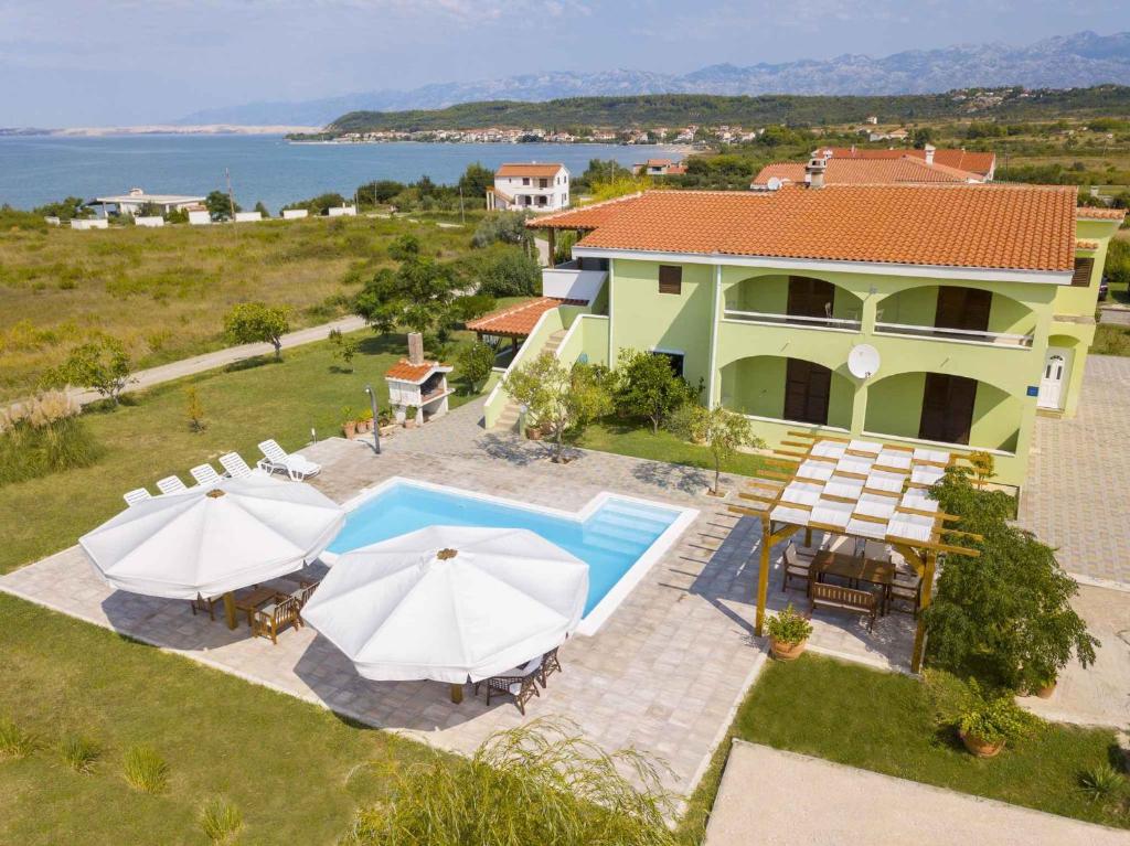 an aerial view of a house with a pool and umbrellas at One-Bedroom Apartment in Ljubac I in Krneša