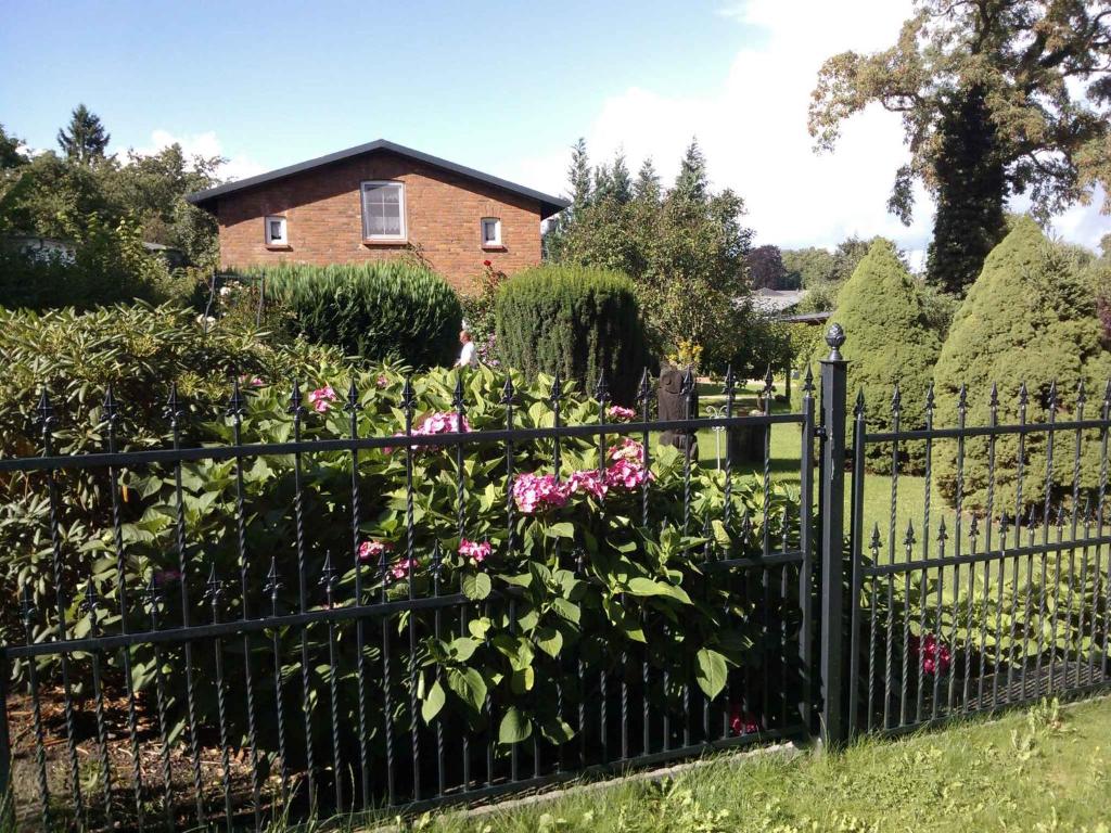 a fence in front of a house with pink flowers at Apartment in Putbus II in Putbus