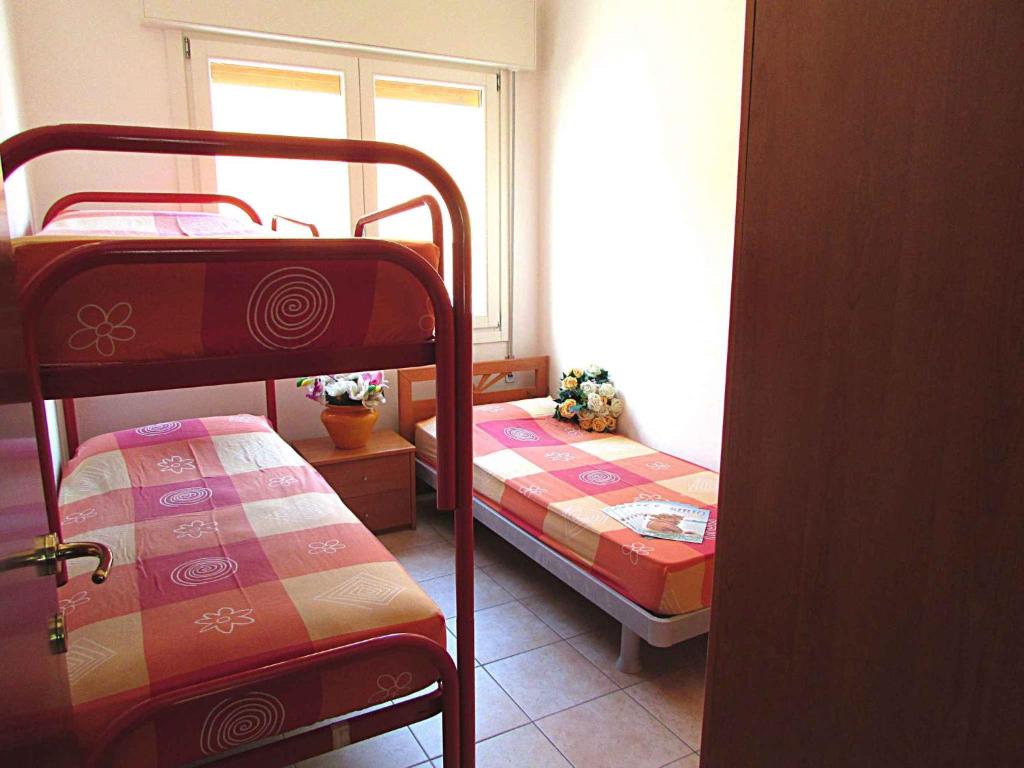 ビビオーネにあるApartment in Bibione 24583のベッドルーム1室(二段ベッド2台、窓付)が備わります。