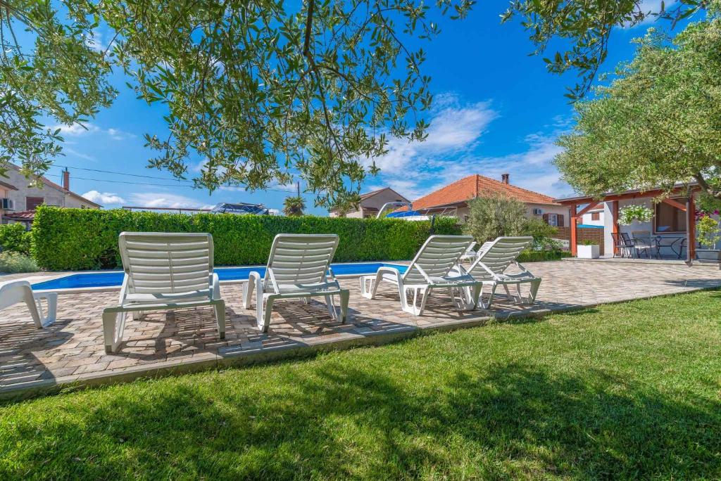 rząd leżaków przy basenie w obiekcie Two-Bedroom Apartment in Biograd na Moru II w Biogradzie na Moru