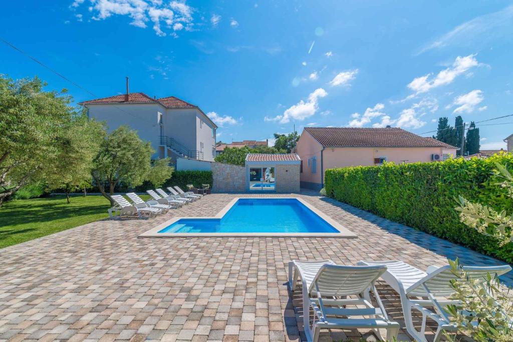 basen z leżakami w ogrodzie w obiekcie Two-Bedroom Apartment in Biograd na Moru II w Biogradzie na Moru