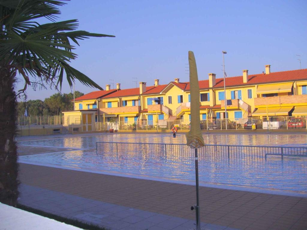 a view of a swimming pool with buildings in the background at Apartments in Rosolina Mare 24858 in Rosapineta