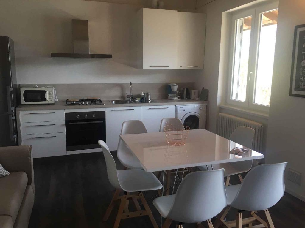 a kitchen with a table and chairs and a kitchen with a stove at Apartments in Pur/Ledrosee 22640 in Mezzolago