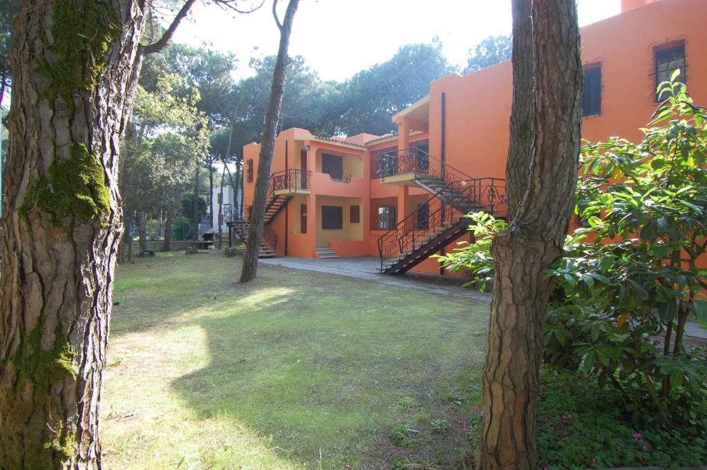 - une vue sur l'extérieur d'un bâtiment oranger avec des arbres dans l'établissement Rosolina Mare Apartment 5, à Rosolina Mare