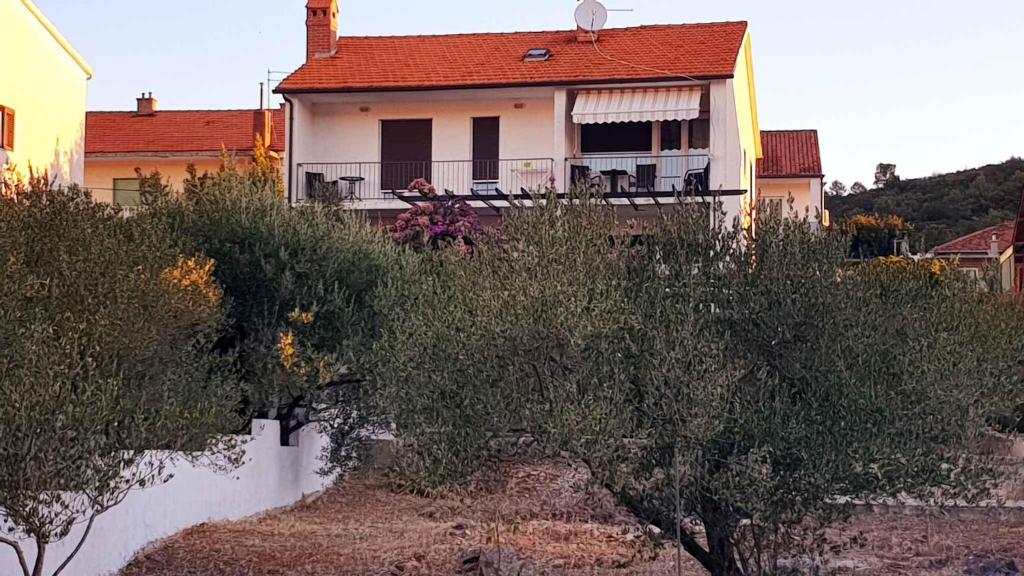 biały dom z balkonem z drzewami przed nim w obiekcie Apartment in Stari Grad/Insel Hvar 6321 w mieście Stari Grad