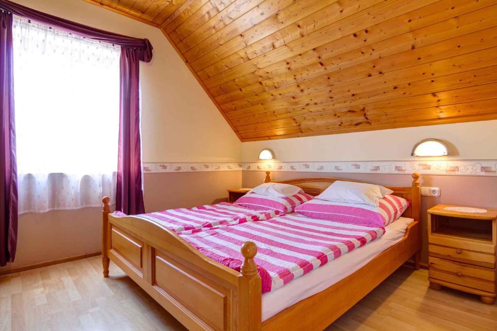 1 dormitorio con 1 cama con techo de madera en Heviz Apartment 5, en Hévíz