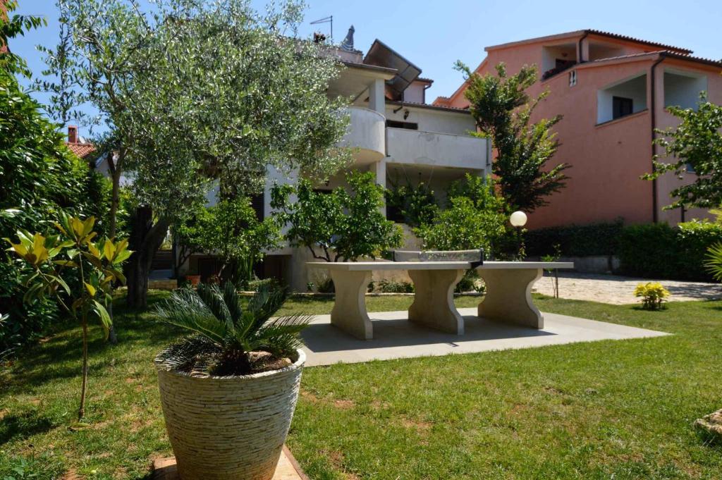 a garden with a table and trees and a building at Apartments in Pjescana Uvala/Istrien 10996 in Pješčana Uvala