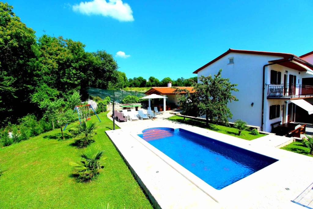 a swimming pool in a yard next to a house at House and Apartments in Labin 8758 in Strmac