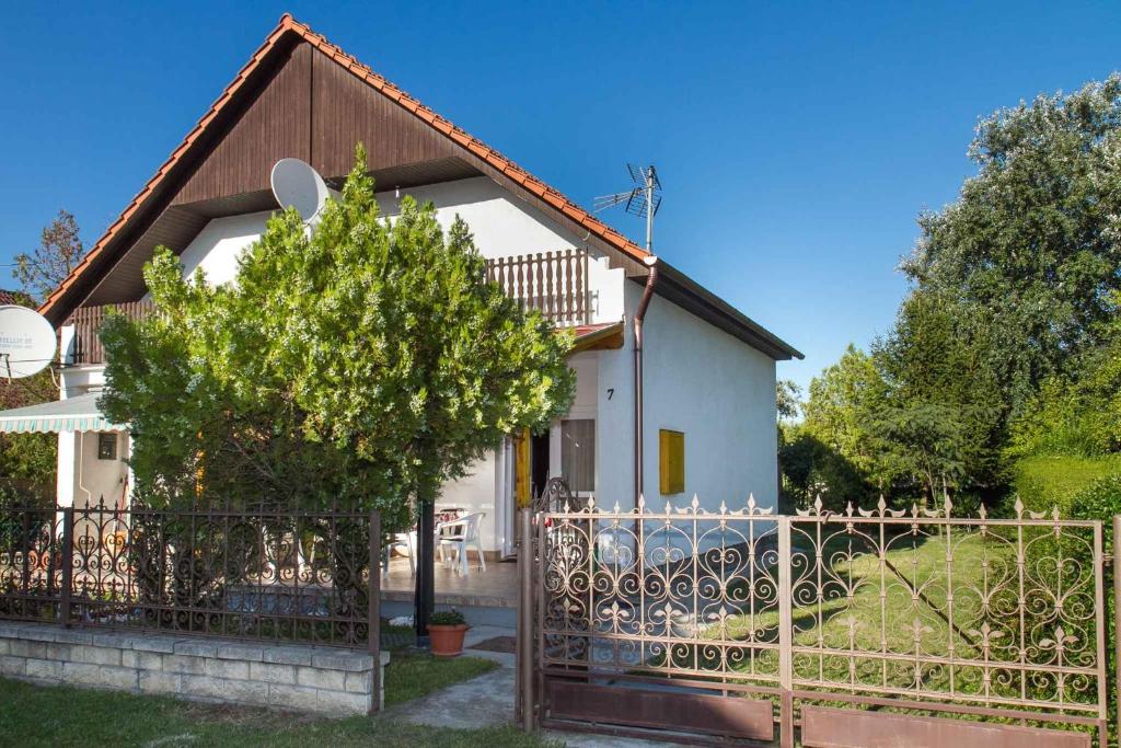 バラトンフェニヴェシュにあるHoliday home in Balatonfenyves 18368の塀と木のある白家