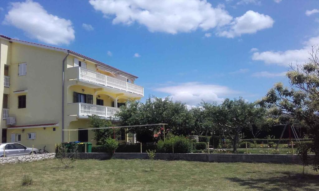a large yellow building with balconies on it at Apartment in Lopar/Insel Rab 17739 in Lopar