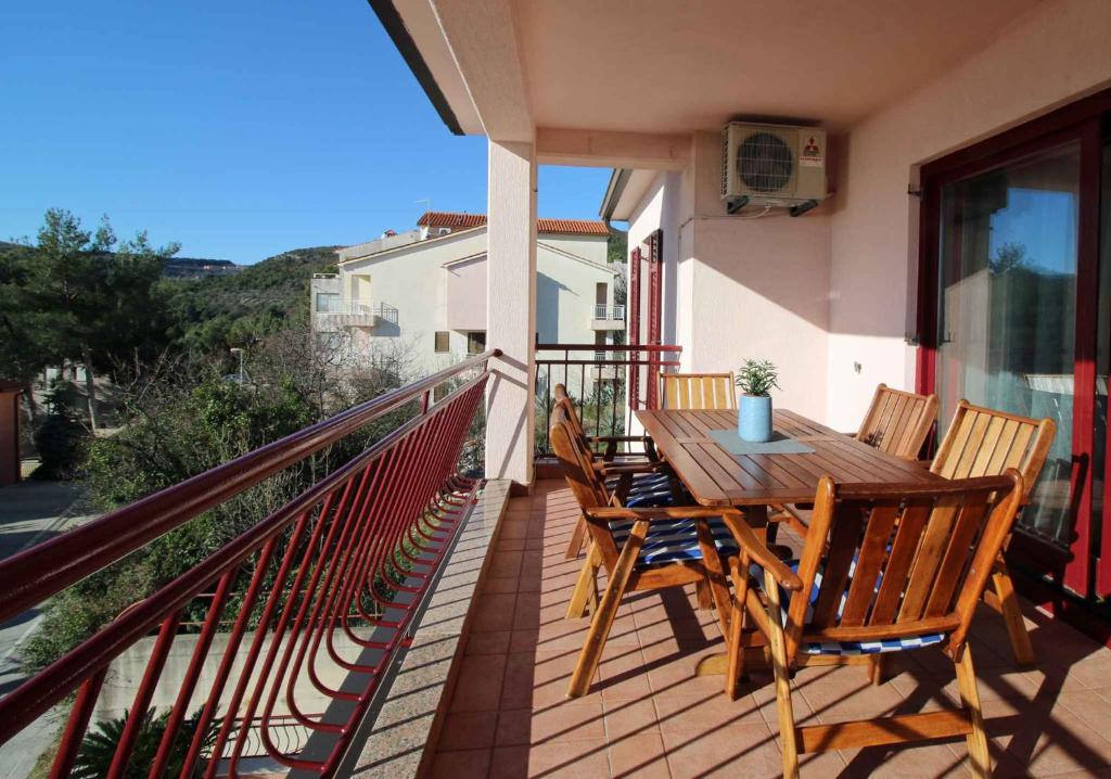 a wooden table and chairs on a balcony at Apartments in Rabac 16693 in Rabac