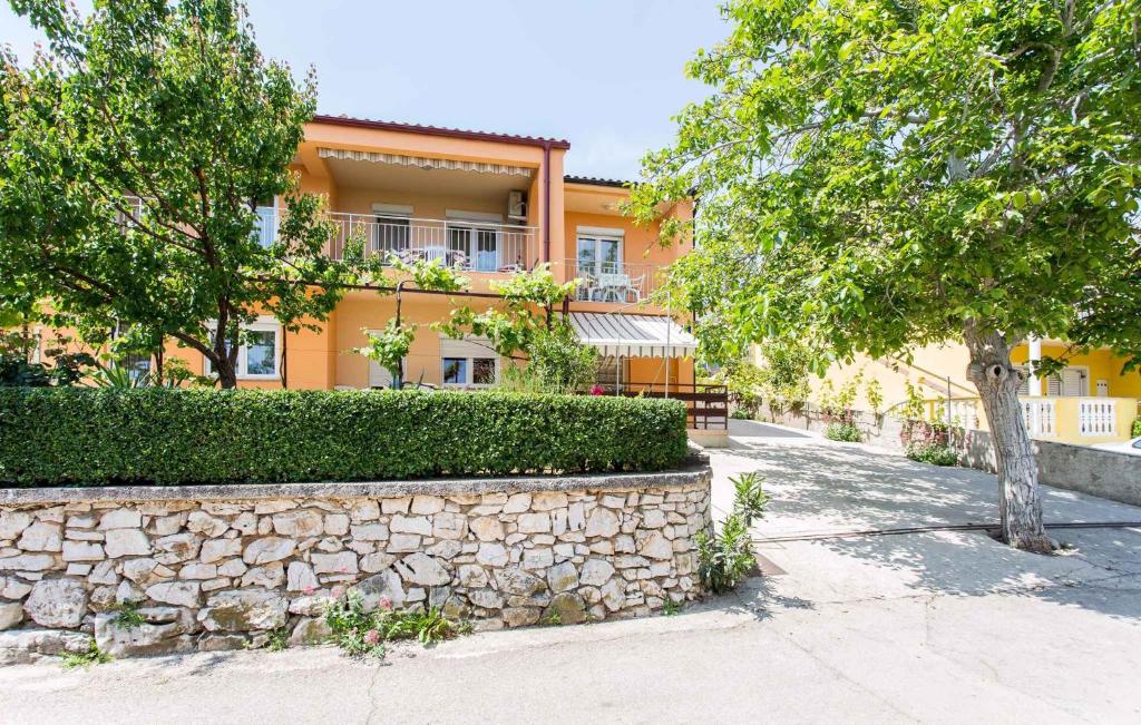an orange building with a stone wall and trees at Apartment in Silo/Insel Krk 13499 in Šilo