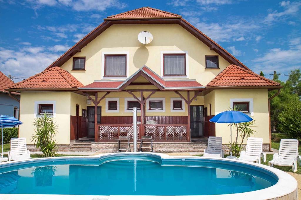 uma casa com piscina em frente a uma casa em Holiday home in Balatonmariafürdo 19511 em Balatonmáriafürdő