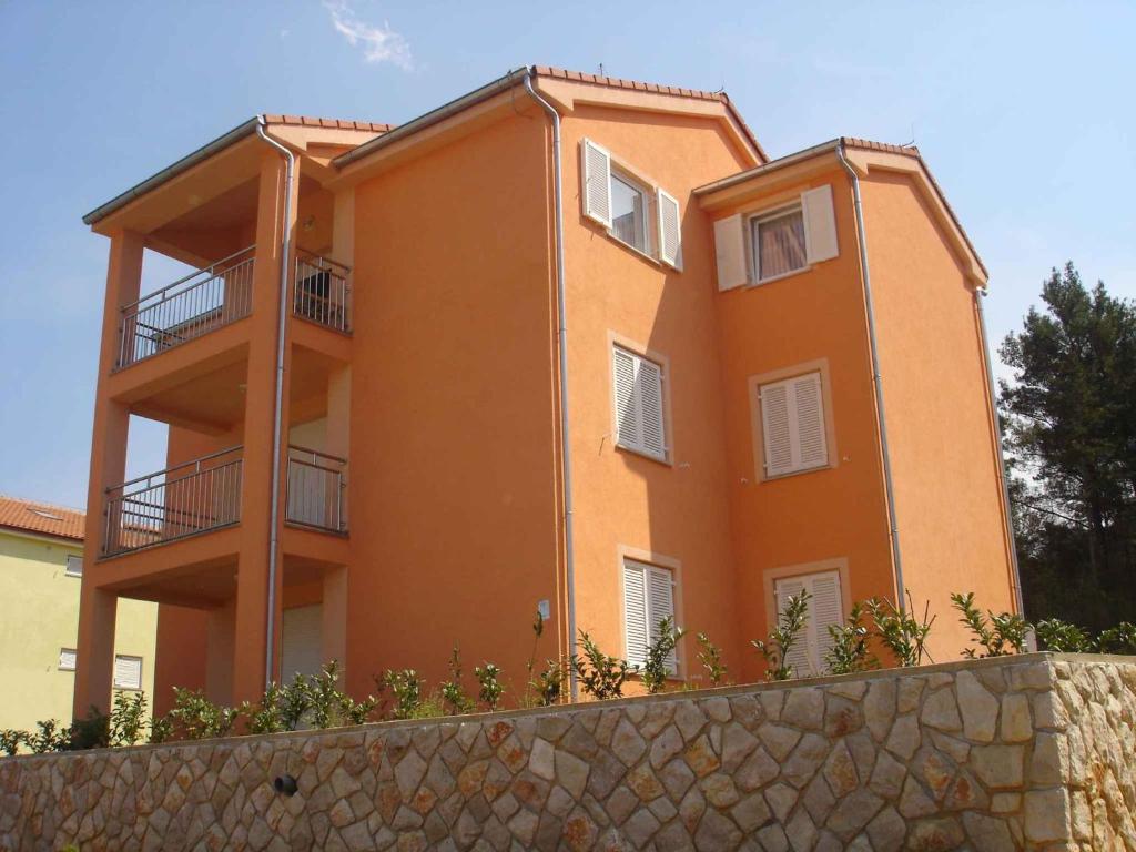 um edifício laranja com varandas no topo de uma parede em Apartment Soline 4 em Soline