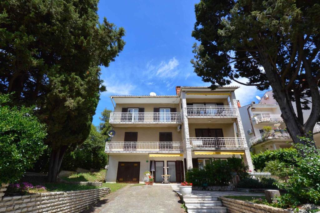 a large white building with a balcony and trees at Apartment in Pula/Istrien 11082 in Veruda