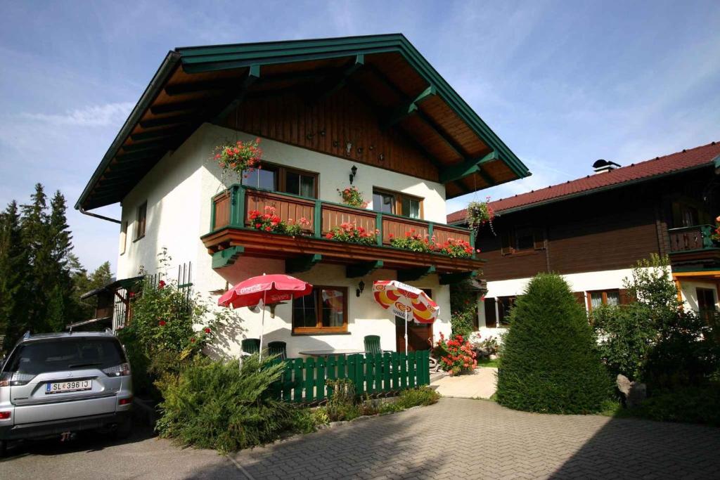 a building with a balcony with flowers on it at Holiday home Strobl/Salzburger Land 103 in Weissenbach