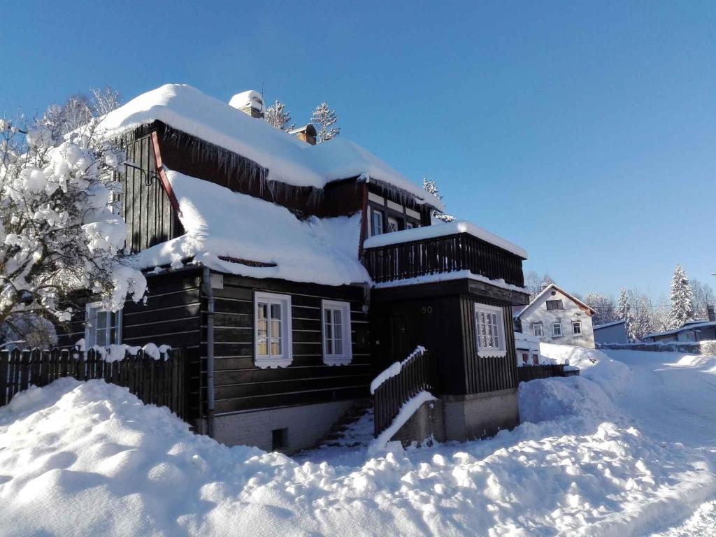una baita di tronchi coperta di neve nel cortile di Holiday home in Josefuv Dul 1726 a Josefŭv Dŭl