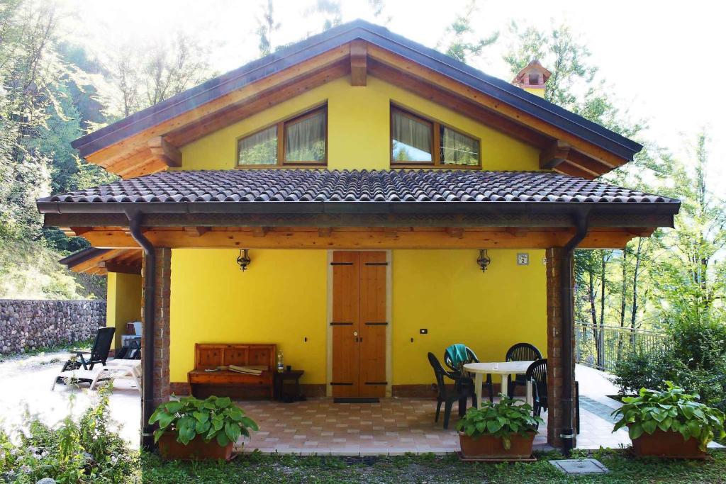 uma casa amarela com uma mesa em frente em Holiday home in Pieve di Ledro 22670 em Ledro