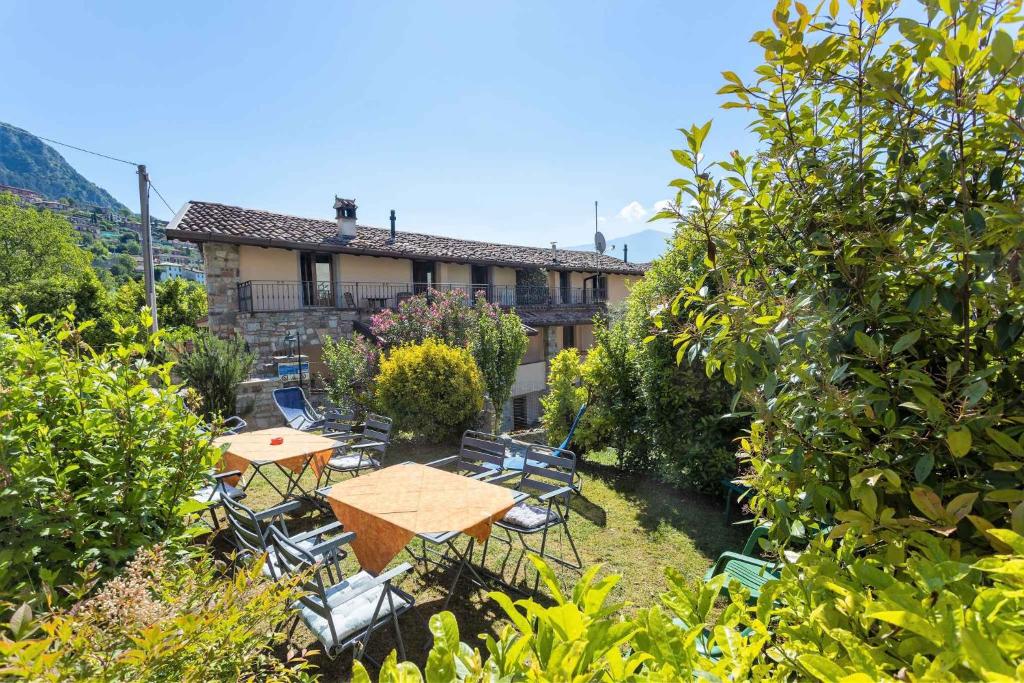 a garden with a table and chairs and a building at Apartment Tremosine 7 in Tremosine Sul Garda