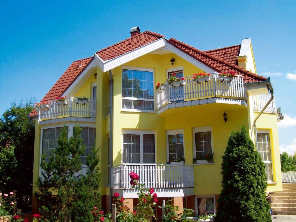 a yellow house with a red roof and windows at Apartment Siofok, Lake Balaton 1 in Siófok
