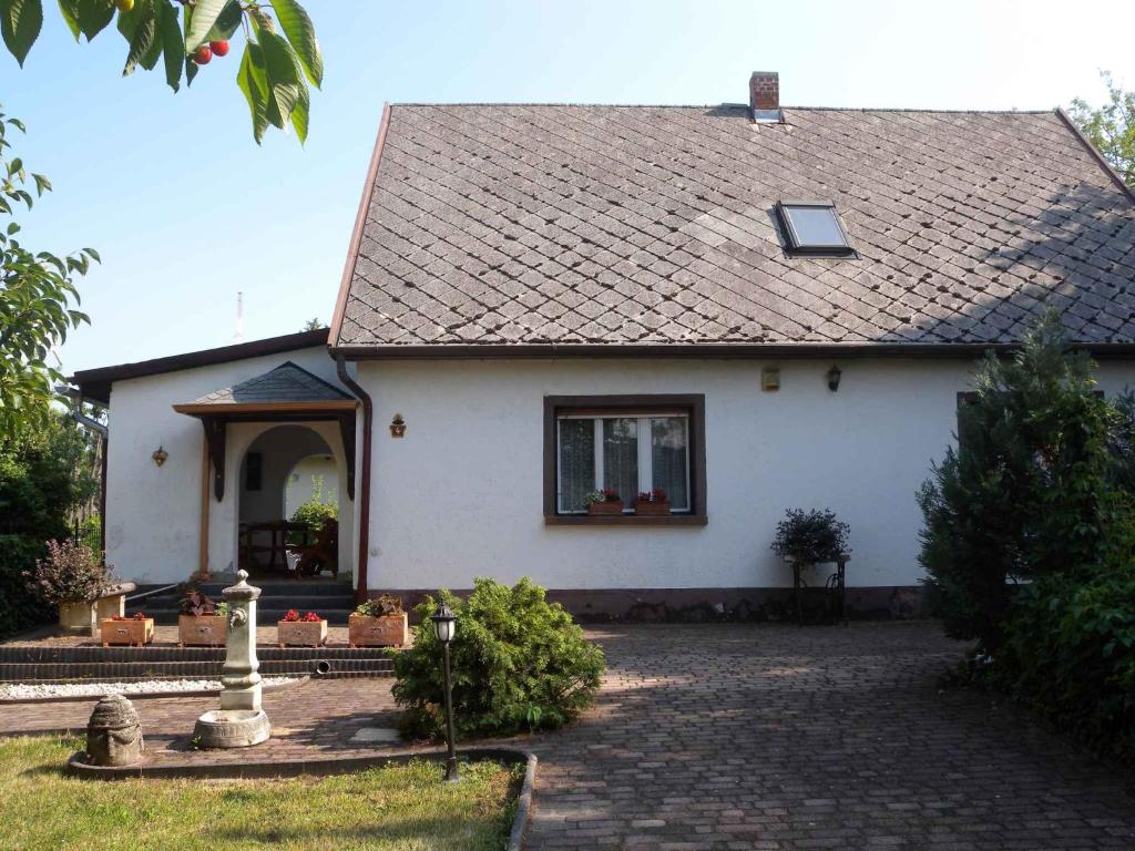 a white house with a tile roof at Holiday home in Siofok/Balaton 19703 in Balatonszabadi Fürdőtelep