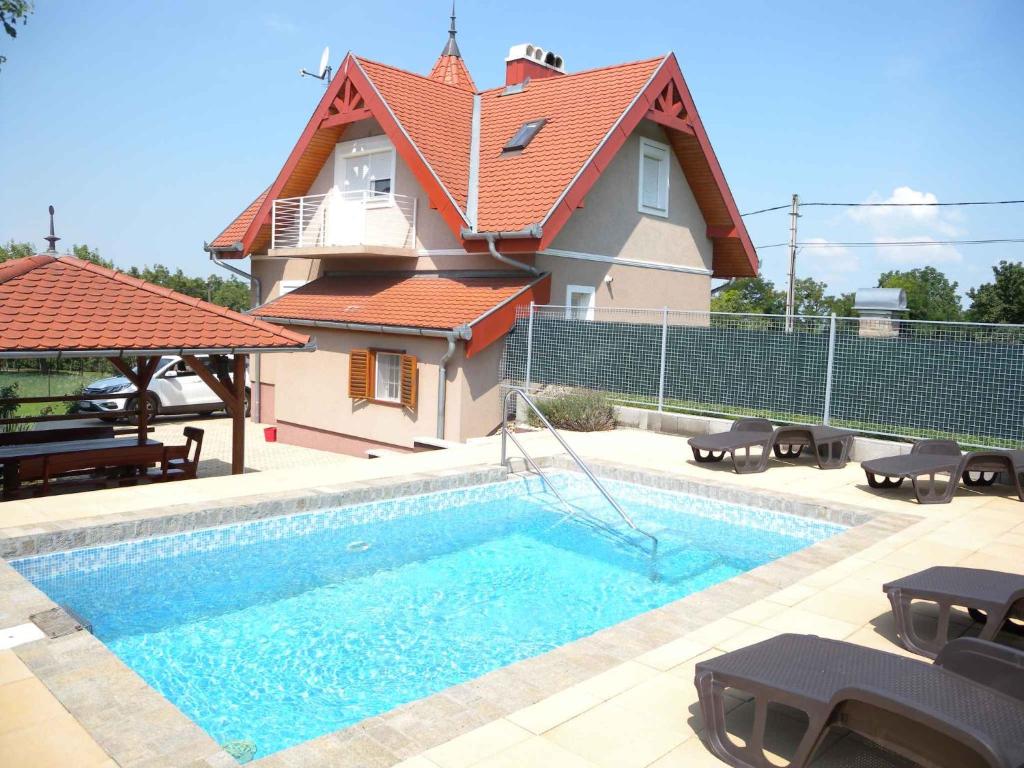 uma casa com piscina em frente a uma casa em Holiday home in Siofok/Balaton 19917 em Somogyfok Szőllőskert