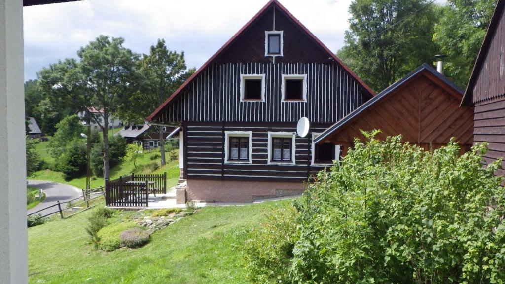 une maison noire avec un toit en gambrel dans l'établissement Holiday home in Jestrabi v Krkonosich 2207, à Roudnice