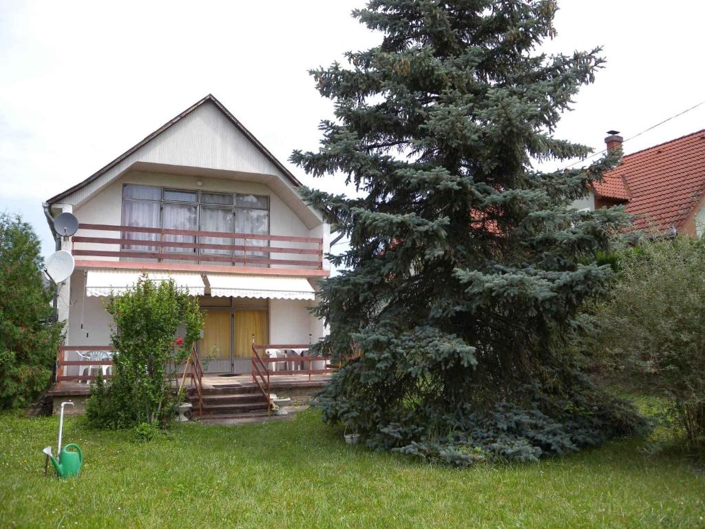 uma casa com um pinheiro em frente em Holiday home in Keszthely/Balaton 18989 em Bolgárkert