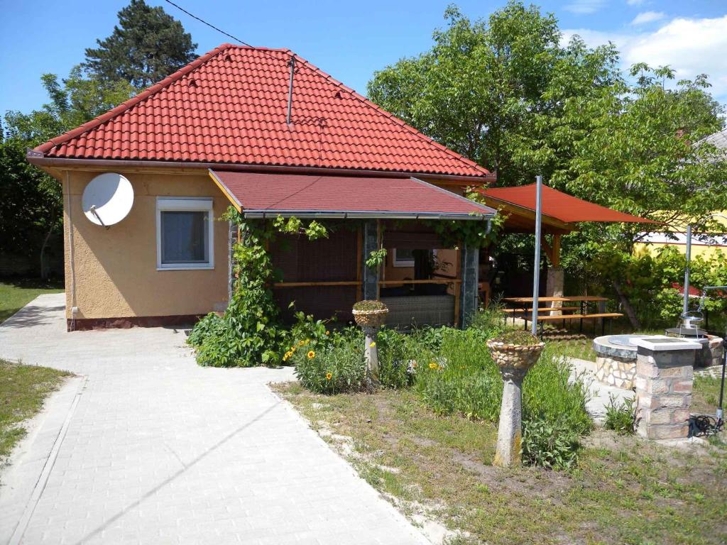 Cette petite maison dispose d'un toit rouge et d'une terrasse. dans l'établissement Holiday home in Fonyod/Balaton 18622, à Balatonfenyves