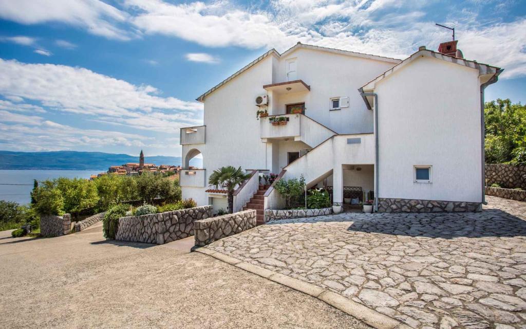 a large white house with a stone driveway at Apartment in Vrbnik/Insel Krk 13612 in Vrbnik