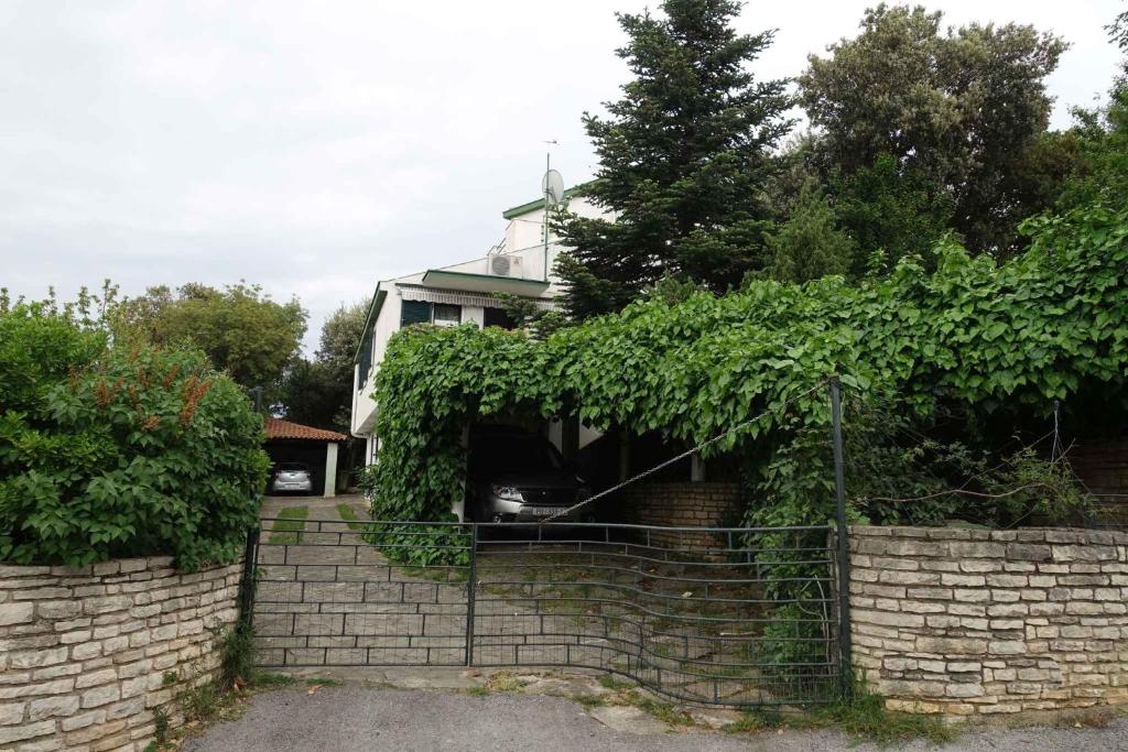 a house with a fence in front of a brick wall at Apartment in Pula/Istrien 10835 in Vintijan