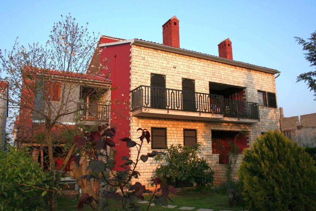 an old brick building with a balcony on it at Apartment Valbandon, Istria 12 in Štinjan