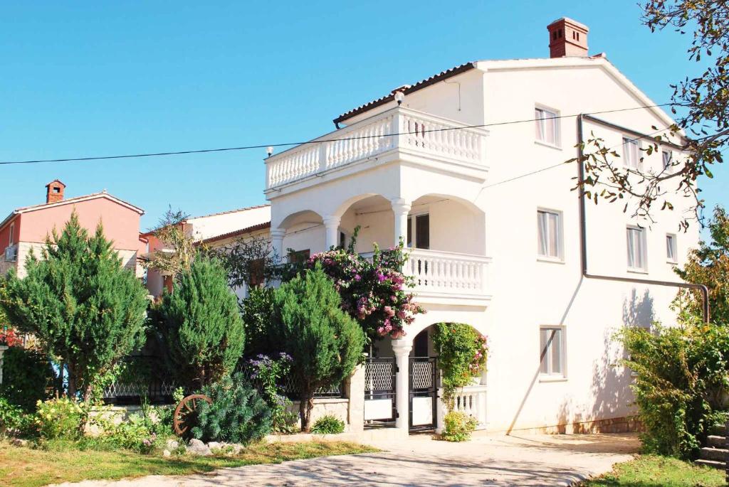 ein großes weißes Haus mit Bäumen davor in der Unterkunft Holiday home in Muntic/Istrien 10956 in Muntić