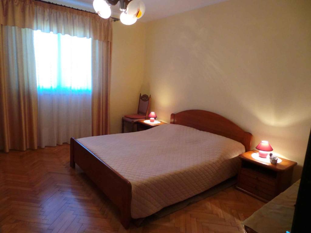 a bedroom with a bed and a window with two lamps at Apartments in Valbandon/Istrien 8381 in Štinjan