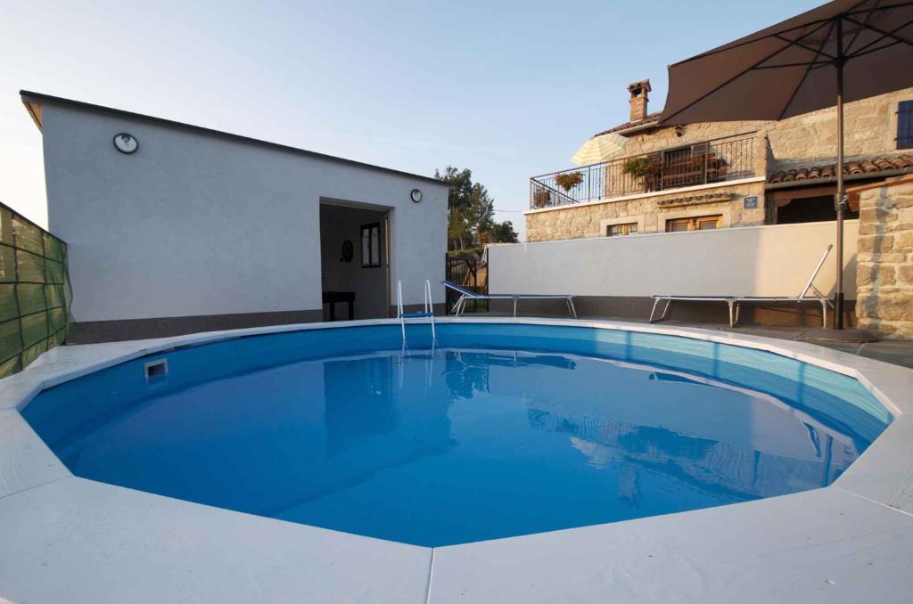 une grande piscine bleue à côté d'un bâtiment dans l'établissement Holiday home in Buzet/Istrien 9974, à Prodani