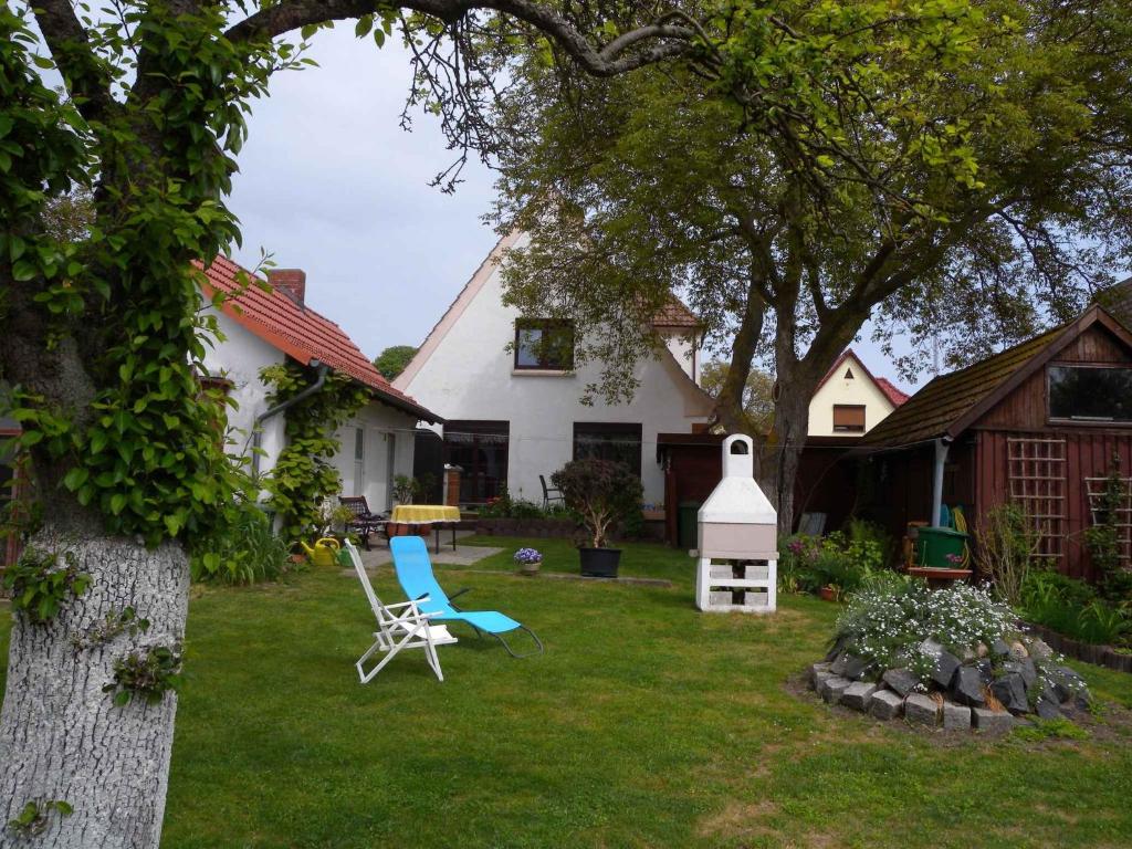einen Garten mit Stühlen und ein weißes Haus in der Unterkunft Apartment in Bergen auf Rügen 2835 in Bergen auf Rügen