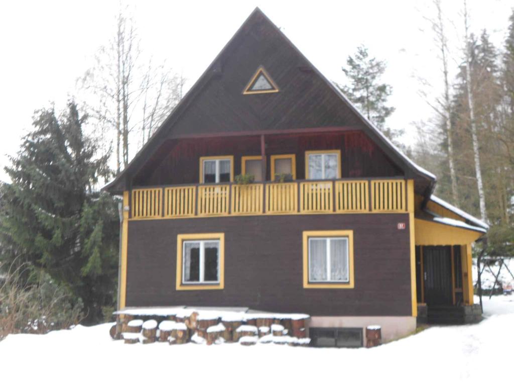 een groot bruin huis met een balkon in de sneeuw bij Holiday home in Dolni Dvur 2374 in Dolni Dvur