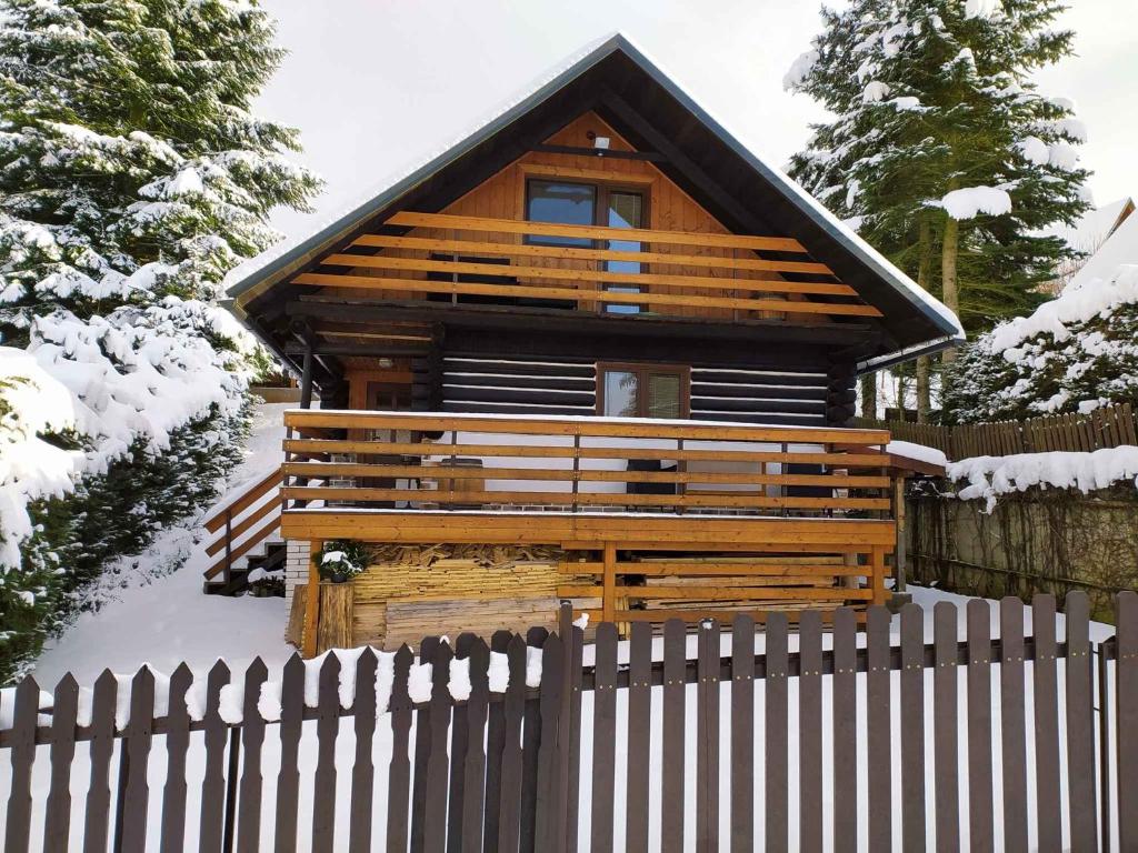 Cabaña de madera con valla en la nieve en Holiday home in Dolce u Trutnova 2310, en Oblanov
