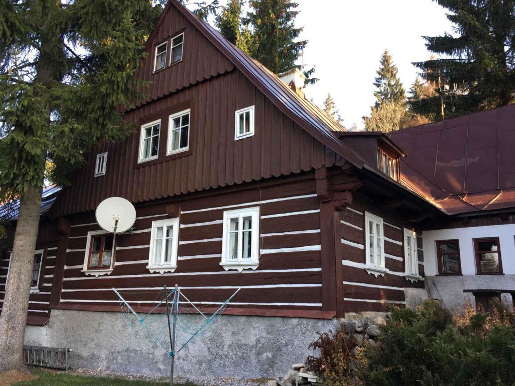 una casa de madera con techo de gambrel en Holiday home in Harrachov 2446, en Nový Svět