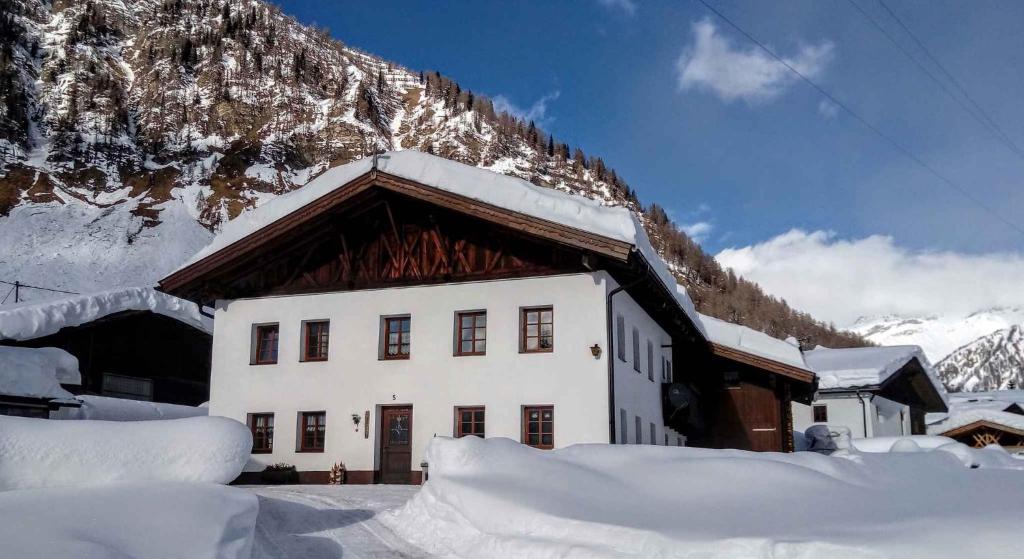 ein schneebedecktes Gebäude vor einem Berg in der Unterkunft Apartment in Schmirn/Tirol 717 in Hochmark