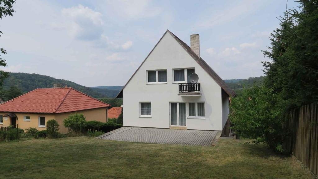 ein weißes Haus mit einem Balkon im Hof in der Unterkunft Holiday home in Krivoklat 1156 in Křivoklát