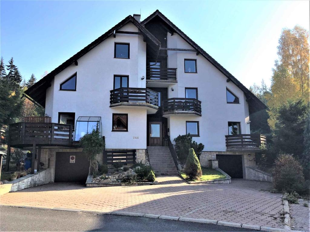 a large white house with a gambrel roof at Apartment Harrachov 10 in Harrachov