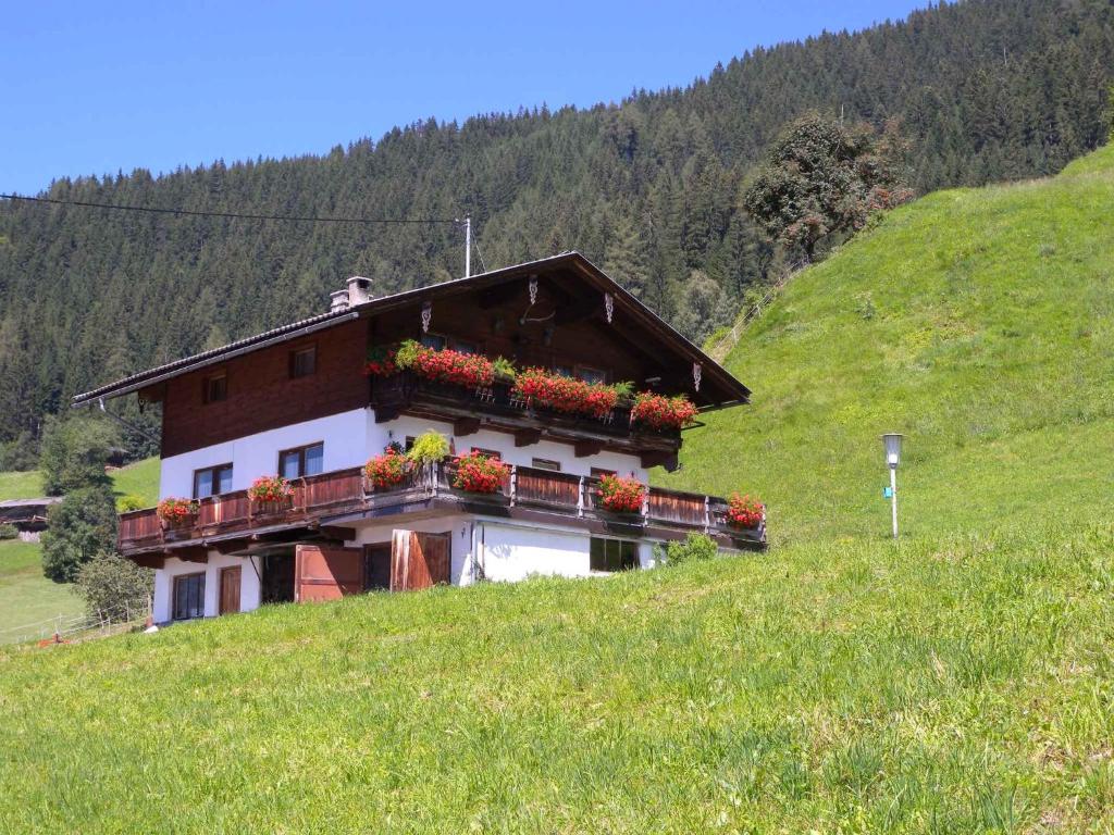 ein Haus auf einem Hügel mit Blumenkästen drauf in der Unterkunft Apartments in Bruck am Ziller/Zillertal 857 in Großhartberg