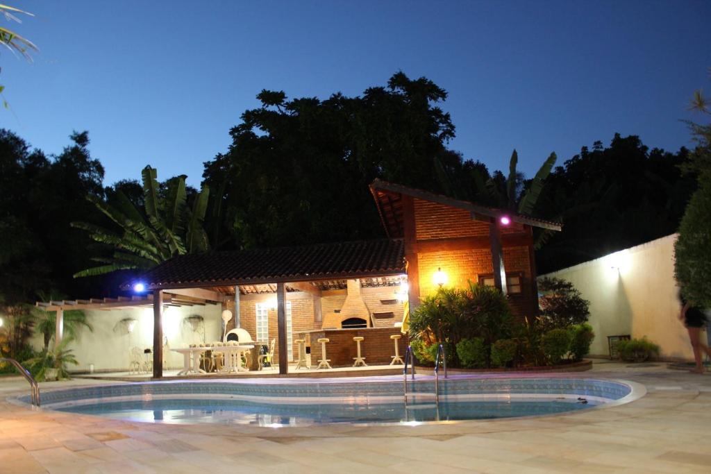 a house with a swimming pool at night at Village Pendotiba in Niterói