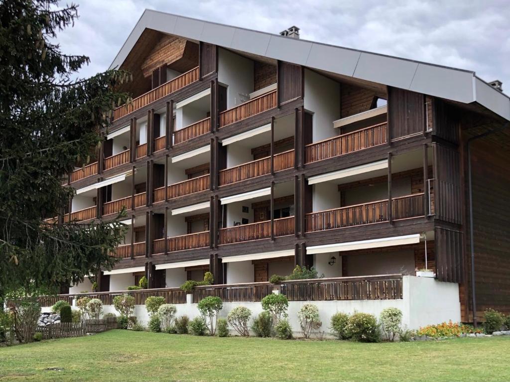 an apartment building with balconies and a yard at Apartment La Berciére 6 in Villars-sur-Ollon