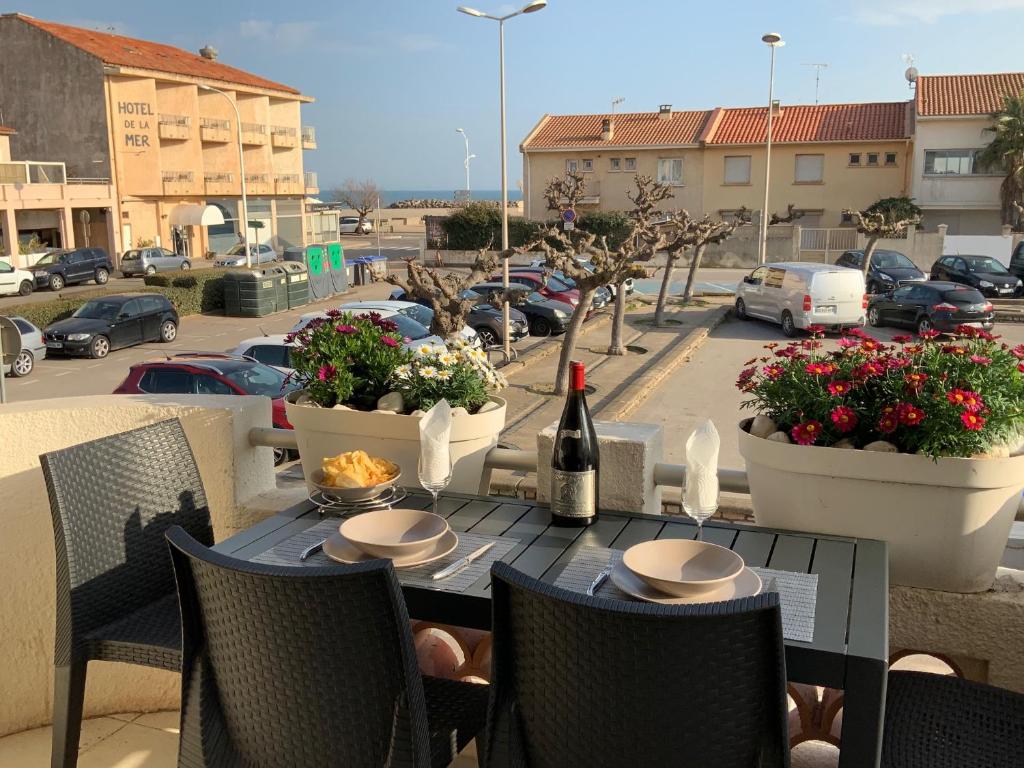 una mesa con una botella de vino en el patio en Villa Magaly T4 à 50 m de la plage de Valras centre, en Valras-Plage