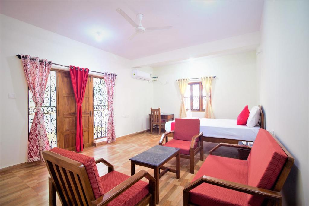 a room with a bed and chairs and a table at Casa Joseph in Candolim