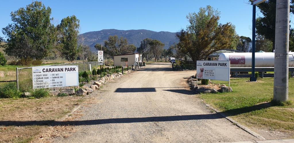 a dirt road with signs on the side of it at Mt Mittamatite Caravan Park in Corryong